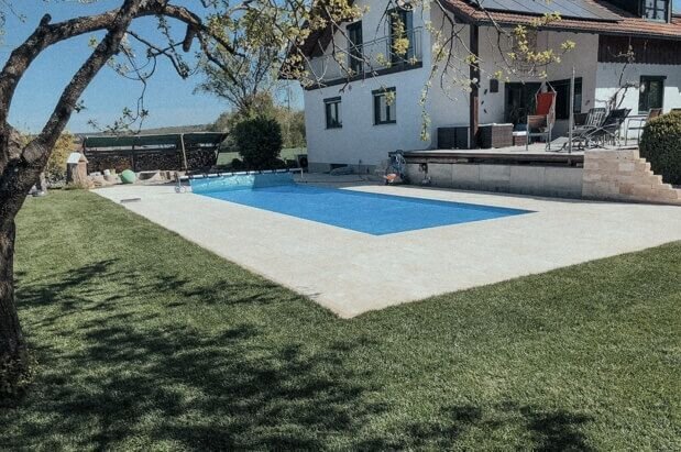 Pool mit Natursteinumrandung in einem neu angelegten Garten